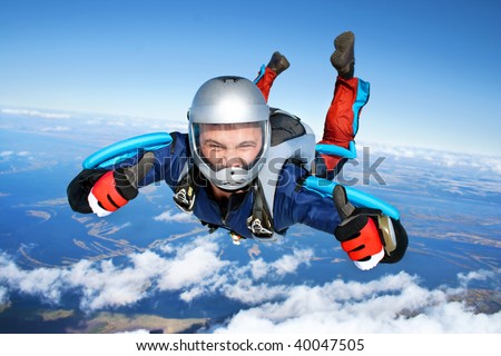 Skydiver falls through the air. All right! Thumbs up! Parachuting is fun!