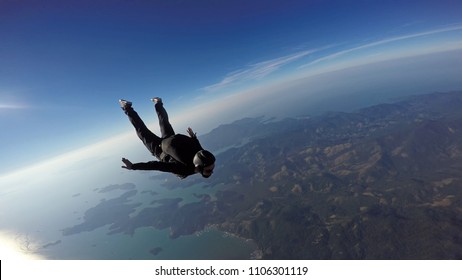 Skydiver jump over the sea and mountains