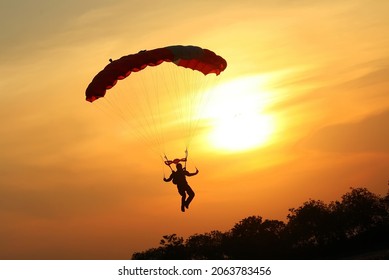 Skydiver aterrizando el paracaídas al atardecer