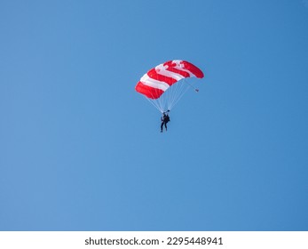 Skydiver with open parachute at yhe blue sky ın a sunny day