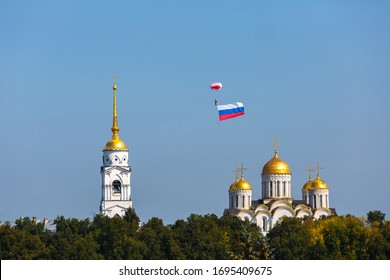 Skydiver with the Russian flag in the sky over the Assumption Cathedral in Vladimir city, Russia.