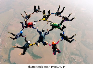 Skydivers holding hands making a formation. High angle view.