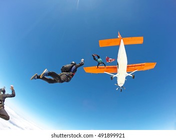 Skydivers Jumping From The Orange Plane