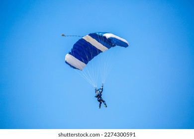 Skydiving. Flying parachutists against the background of the blue sky and mountains. Extreme sport and entertainment. - Powered by Shutterstock