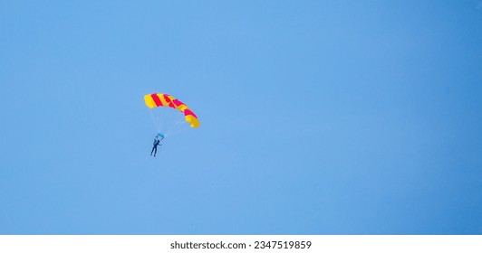 Buceo en paracaídas. Paracaidistas voladores contra el fondo del cielo azul y las montañas. Deporte extremo y entretenimiento.