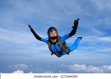 Skydiving. Girl in blue suit is in the sky.