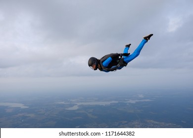 Skydiving. Girl in blue suit is in the sky.