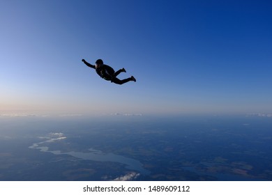 Skydiving. Girl Is Flying In The Sunset Sky.