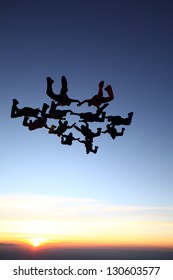 Skydiving Group In Free Fall At Sunset Sky