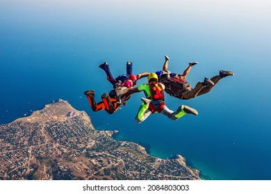Skydiving group over the sea - Shutterstock ID 2084803003