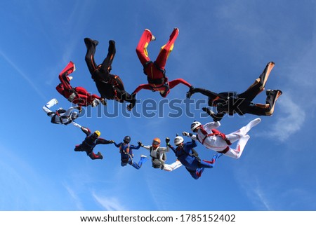 Skydiving. A group of skydivers is training and flying in the sky.