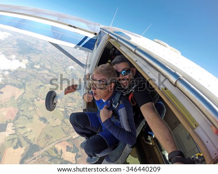 Skydiving. Happy Instructor and student screaming in aircraft door.
