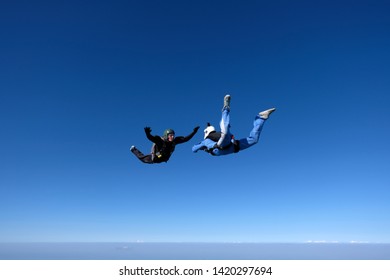 Skydiving. An Instructor Girl In A Blue Suit Trains A Student To Fly.