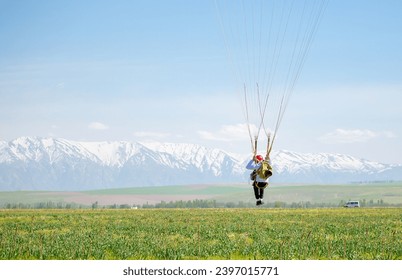 Skydiving. The landed parachutists collect the parachute canopy on the ground. Extreme sport and entertainment.