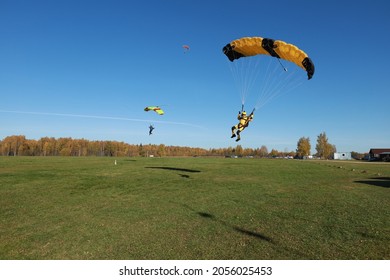 Skydiving. Skydivers are landing on the field.