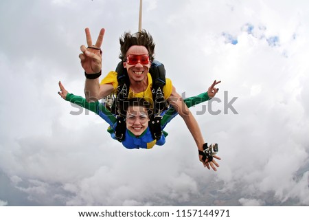 Skydiving tandem happiness on a cloudy day