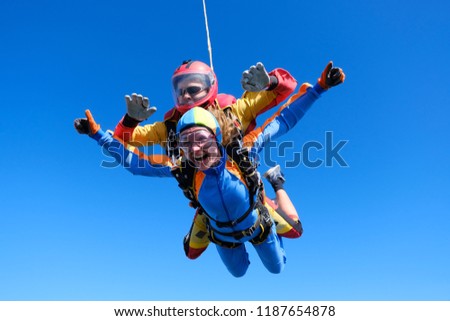 Skydiving. Tandem jump. Passenger is having fun.
