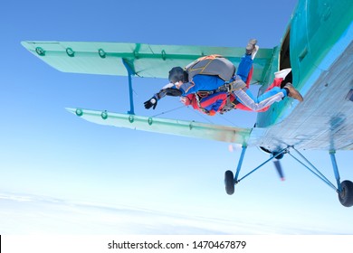 Skydiving. Tandem jump. A strong man and young woman are falling in the sky.