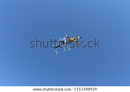 Skydiving. Two instructors are training a skydiver-student to fly.