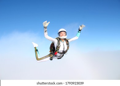 Skydiving. An young woman is flying in the sky.
