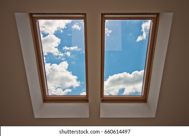 Skylights. View from the window. View of the sky from the window. Window on the roof. Sunlight through the attic window. Light in the house

