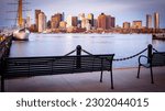 The skyline of Boston in Massachusetts, USA at sunrise as seen from East Boston across the channel with its mix of contemporary and historic buildings.