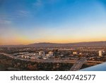 Skyline cityscape of highrise skyscrapers and highway toll road in San Jose California during sunset in aerial view