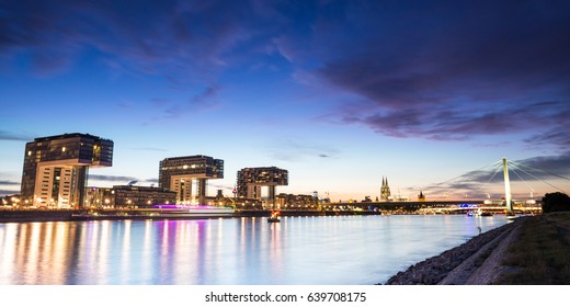 Skyline Of Cologne, Germany With Crane Houses And Cathedral After Sunset.