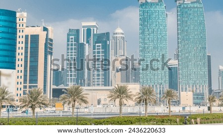 The skyline of Doha seen from Park timelapse, Qatar. Trees and palms on foreground. Modern skyscrapers and towers on background. Traffic on road