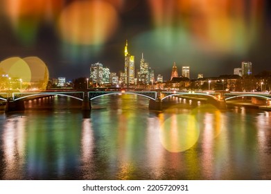 The skyline of Frankfurt am Main in the evening photographed through a reflecting window pane with light reflexes - Shutterstock ID 2205720931