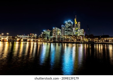 The skyline of Frankfurt - Main at night at a cold day in winter with colorful reflections in the water. Taken as a longexposure.