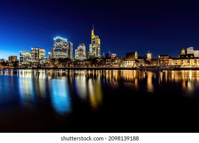 The skyline of Frankfurt - Main at night at a cold day in winter with colorful reflections in the water. Taken as a longexposure.