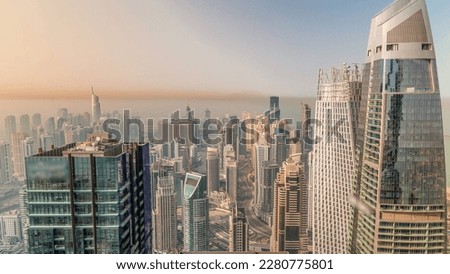 Skyline panoramic view of Dubai Marina showing an artificial canal surrounded by skyscrapers with glass surface along shoreline aerial at morning. Floating yachts and boats. DUBAI, UAE