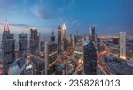 Skyline panoramic view of the high-rise buildings on Sheikh Zayed Road in Dubai aerial day to night transition timelapse, UAE. Illuminated skyscrapers in International Financial Centre from above