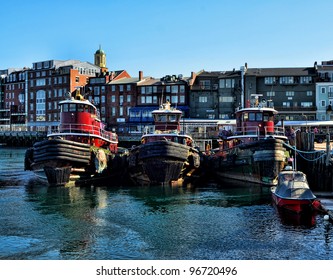Skyline of Portsmouth, New Hampshire with tugboats in foreground.