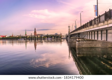 Skyline of Riga and the river Daugava in the morning, Latvia. Riga castle, St. Saviour's Anglican Church, Church of St. Jacob, Dome cathedral, Stone bridge from left to right . Delicate pink morning