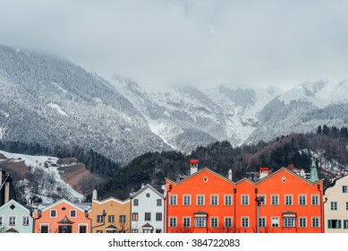 Skyline of Scandinavian style colorful houses in a line with high snowy mountains in the background - Shutterstock ID 384722083