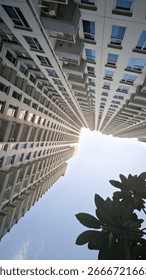 Skyscraper apartment buildings captured from a low angle view against the clear sky. Modern urban architecture and cityscape concept, perfect for real estate, construction, and business themes