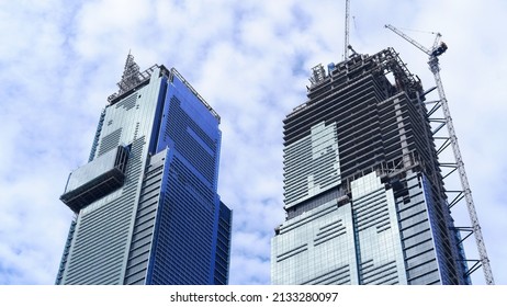 Skyscraper building under construction with tower crane and blue sky background 