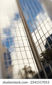 Skyscraper, city and low angle in future, mirror and sky with postmodern architecture for urban expansion. Office building, reflection and metro with property, windows and real estate in Germany
