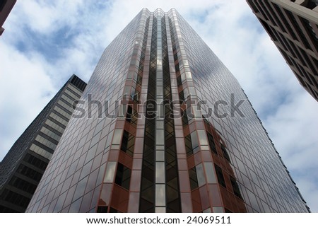 Skyscraper in downtown city, with simultaneous reflection of the side facets