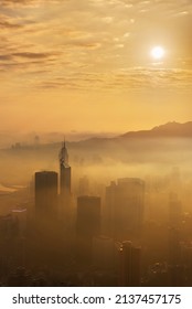 Skyscraper In Downtown District Of Hong Kong City In Fog Under Sunrise