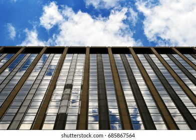 Skyscraper in front of sunny & cloudy sky