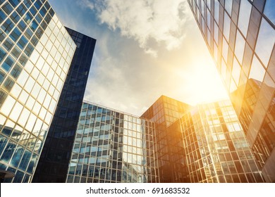 Skyscraper glass facades on a bright sunny day with sunbeams in the blue sky. Modern buildings in Paris business district La Defense. Economy, finances, business activity concept. Bottom up view - Powered by Shutterstock