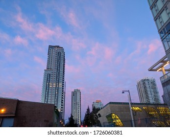skyscraper surrounded by pink clouds 