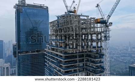 Skyscraper under construction, with crane on top, for urban and industrial themes