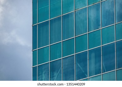 Skyscraper wall with the reflection of the cloudy sky in the windows