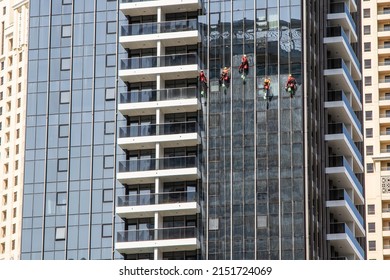 Skyscraper Window Cleaning. Workers On Cables Wash The Windows Of A High-rise Building