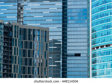 skyscraper windows reflecting bright cloudy sky
