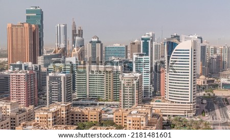 Skyscrapers in Barsha Heights district and low rise buildings in Greens district aerial timelapse. Dubai skyline with palms and trees